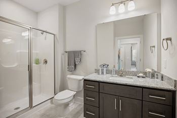 A bathroom with a shower sink and toilet and a mirror